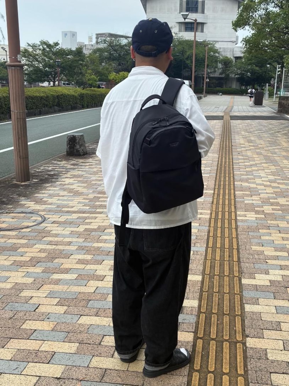 ブラック系のバックパック/リュックを着用したメンズの夏コーディネートの1枚目の写真