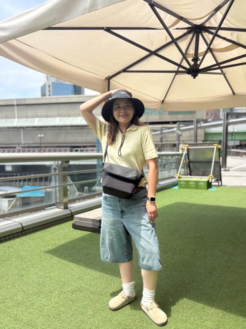 ブラック系のメッセンジャーバッグを着用したレディースの夏コーディネートの1枚目の写真