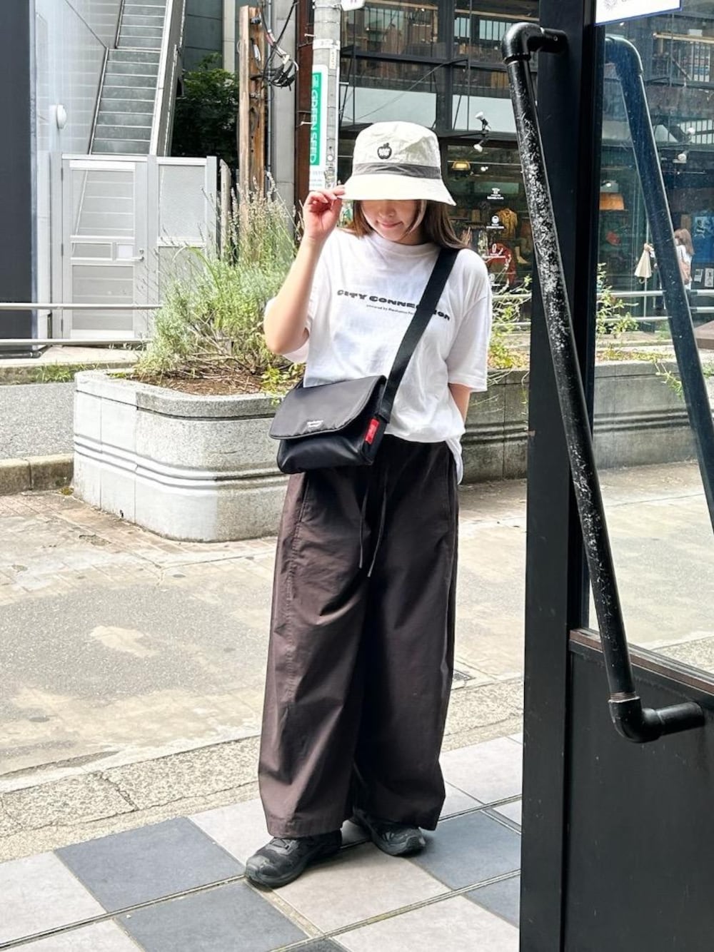 ブラック系のショルダーバッグを着用したレディースの夏コーディネートの1枚目の写真