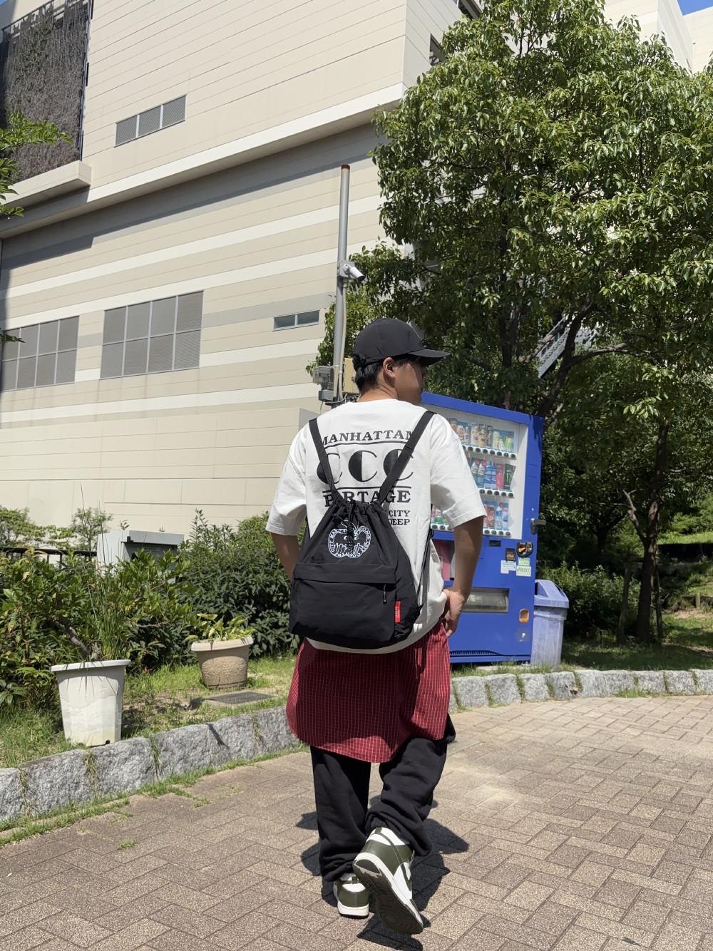 ブラック系のバックパック/リュック、ホワイト系のTシャツ/カットソー、ブラック系のキャップを着用したメンズの夏コーディネートの1枚目の写真
