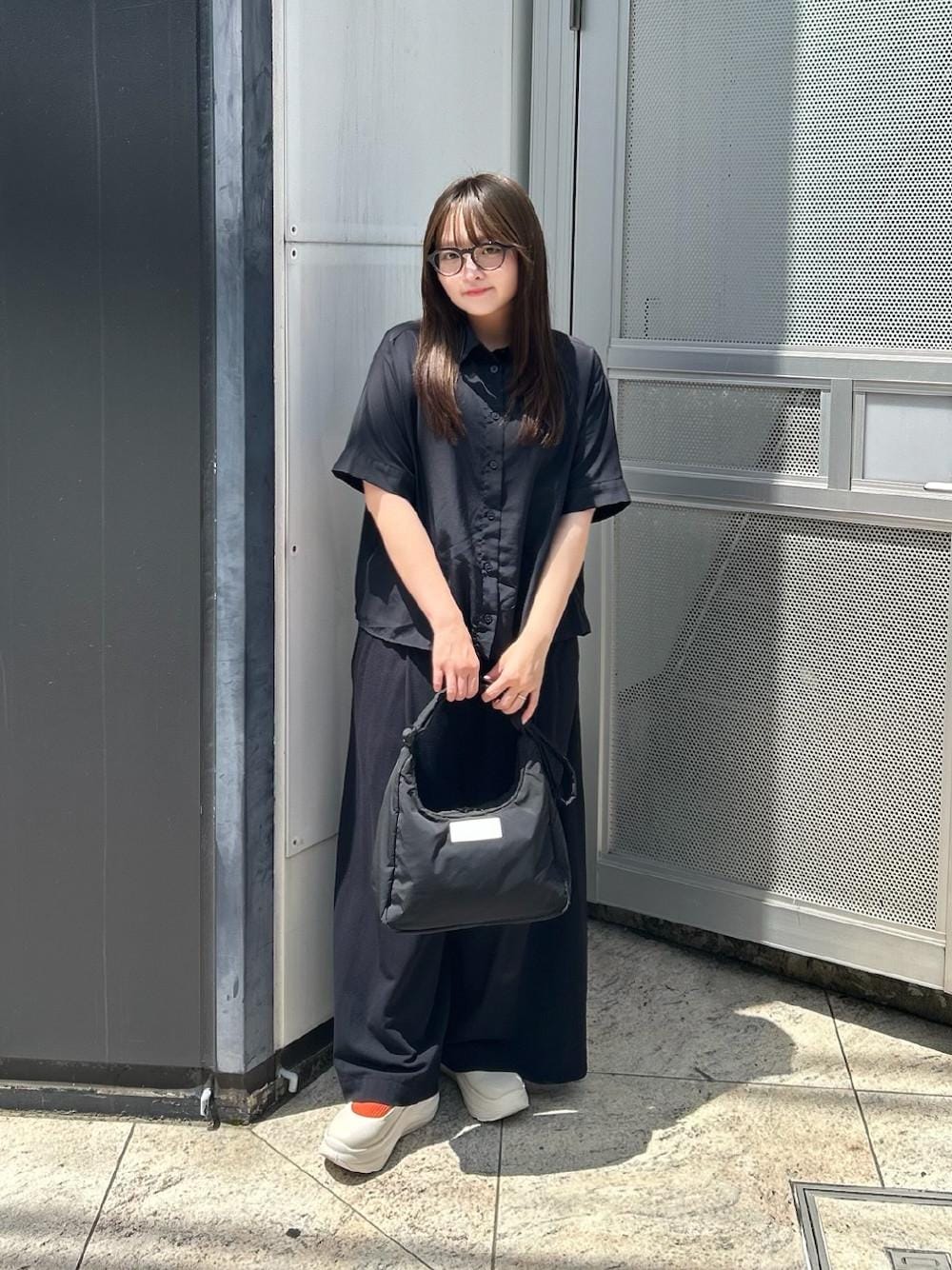 ブラック系のショルダーバッグを着用したレディースの夏コーディネートの1枚目の写真
