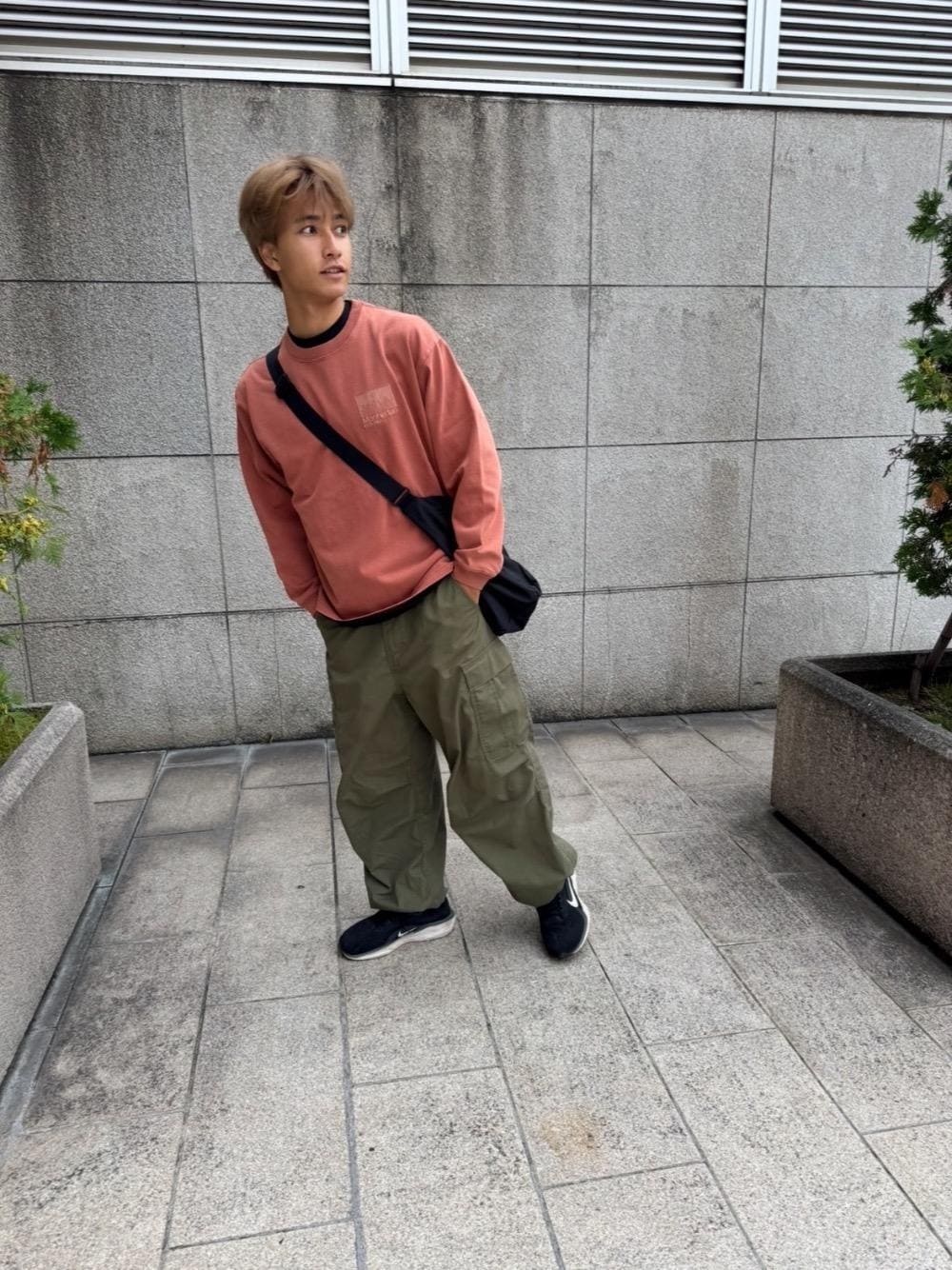 ブラック系のショルダーバッグ、レッド系のTシャツ/カットソーを着用したメンズの夏コーディネートの1枚目の写真