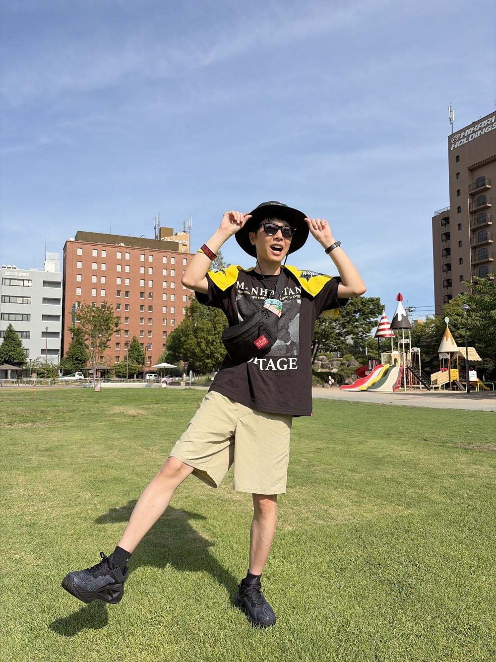 ブラック系のボディバッグ/ウエストポーチ、ブラック系のTシャツ/カットソー、ブラック系のハットを着用したメンズの夏コーディネートの1枚目の写真