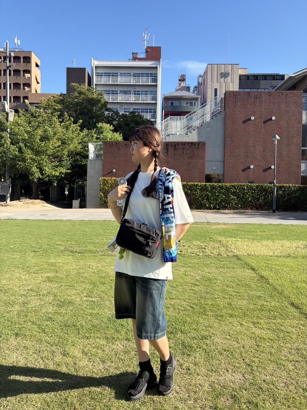 ブラック系のショルダーバッグ、ホワイト系のTシャツ/カットソーを着用したレディースの夏コーディネートの1枚目の写真