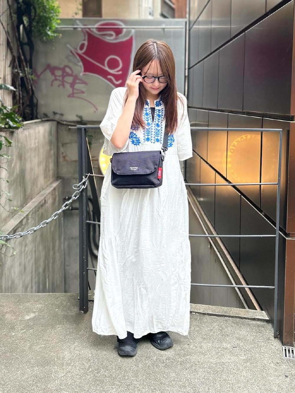 ブラック系のショルダーバッグを着用したレディースの夏コーディネートの1枚目の写真
