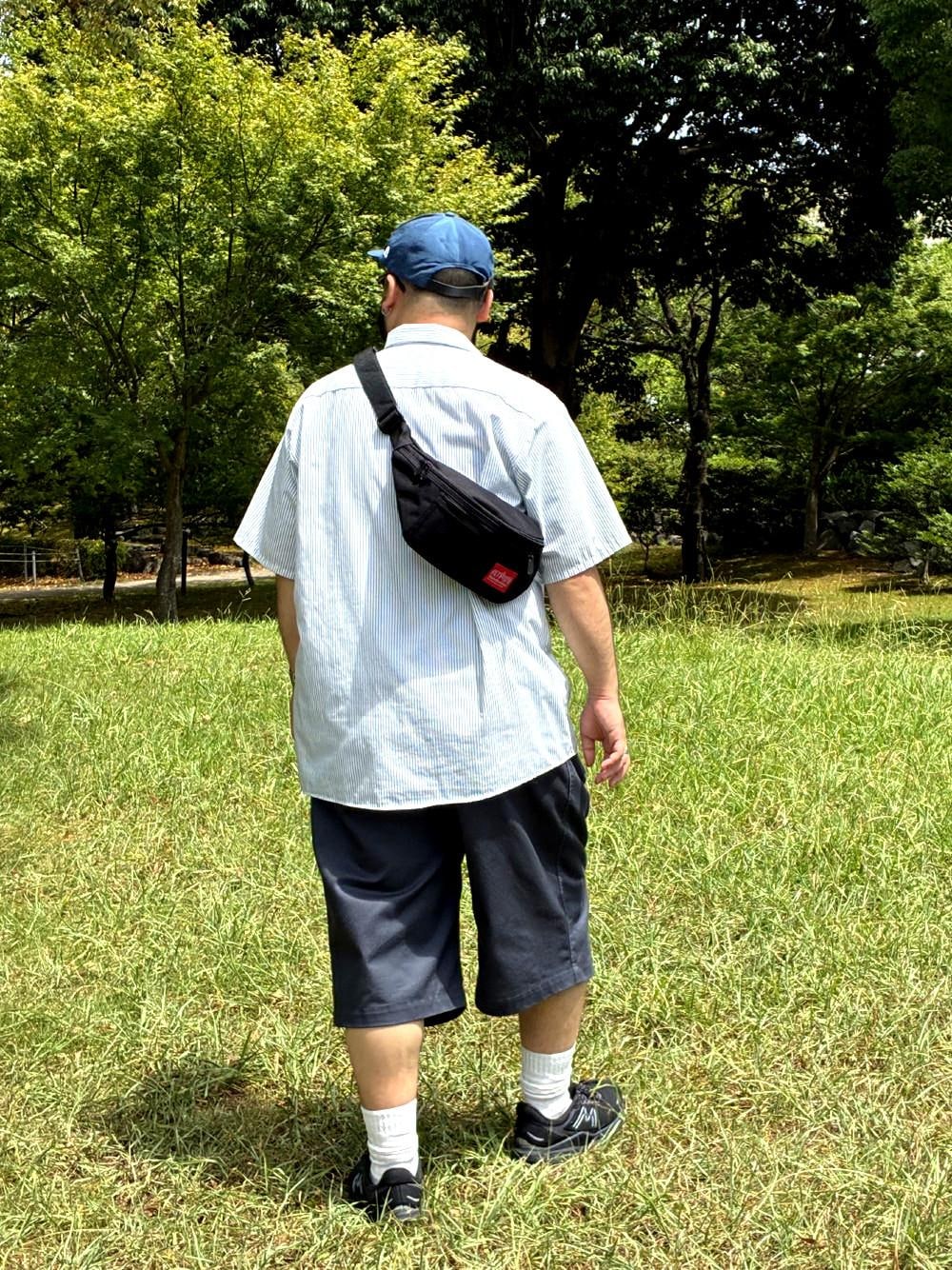 ブラック系のボディバッグ/ウエストポーチを着用したメンズの夏コーディネートの1枚目の写真