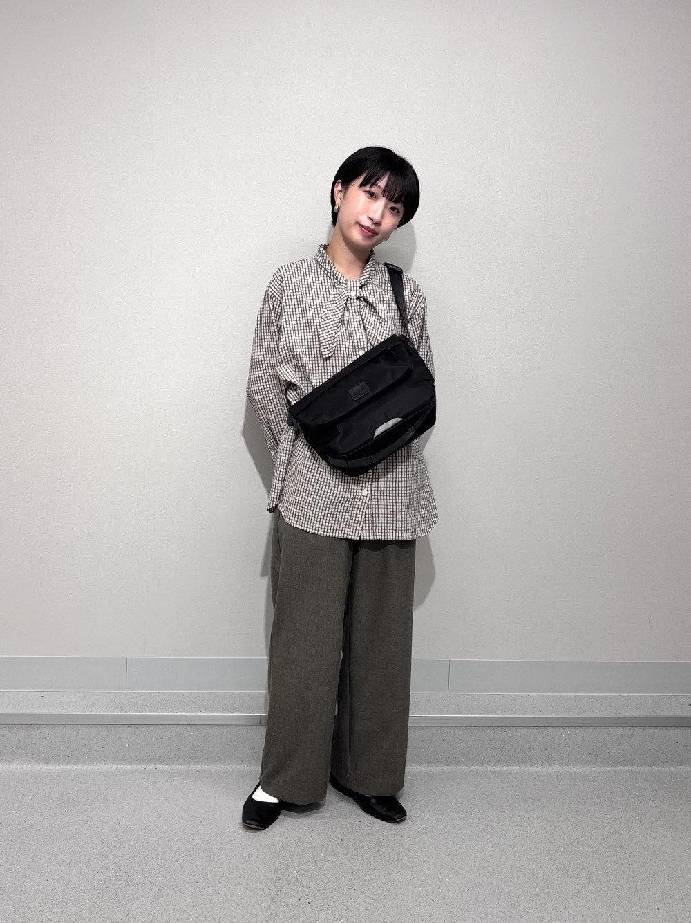 ブラック系のメッセンジャーバッグを着用したレディースの秋コーディネートの1枚目の写真
