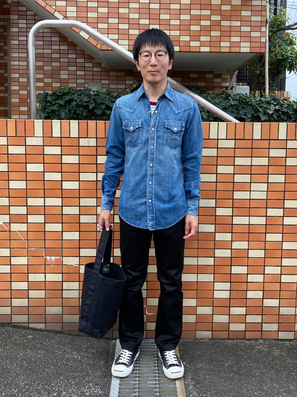 ブルー系のシャツ/ブラウス、ブラック系のチノパンツ、ブラック系のスニーカーを着用したメンズの秋コーディネートの1枚目の写真