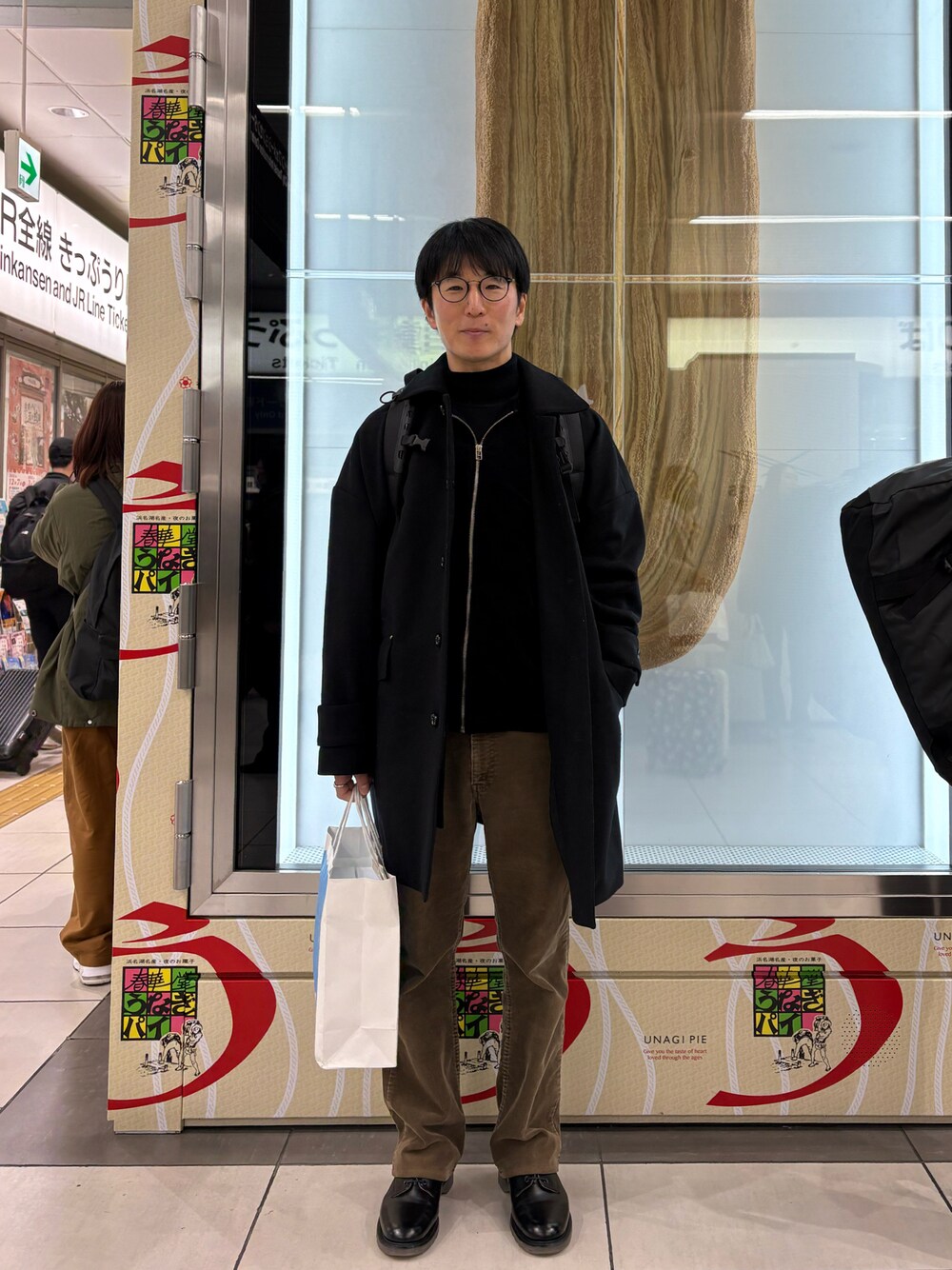 「うなぎパイ、巨うなぎパイ」｜「MackintoshのHUMBIE GTS  36  BLACK（ステンカラーコート、ブラック系）」を使った、Daisuke Aさん（メンズ・168cm）の冬コーディネートの1枚目の写真
