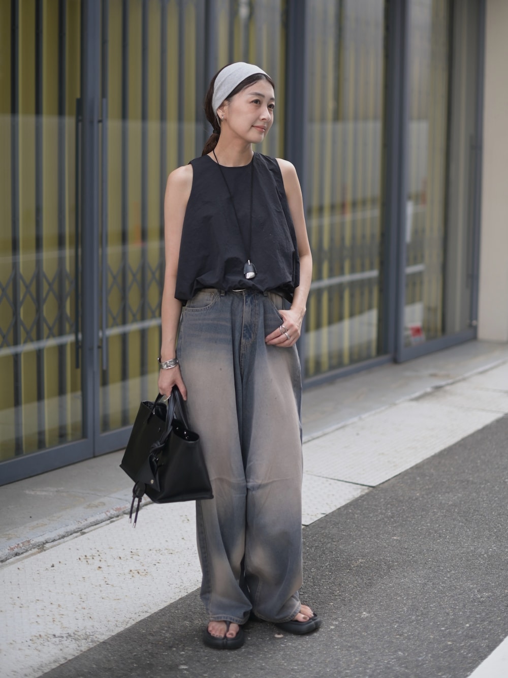 ブルー系のデニムパンツ、ブラック系のシャツ/ブラウス、ブラック系のトートバッグを着用したレディースの夏コーディネートの1枚目の写真