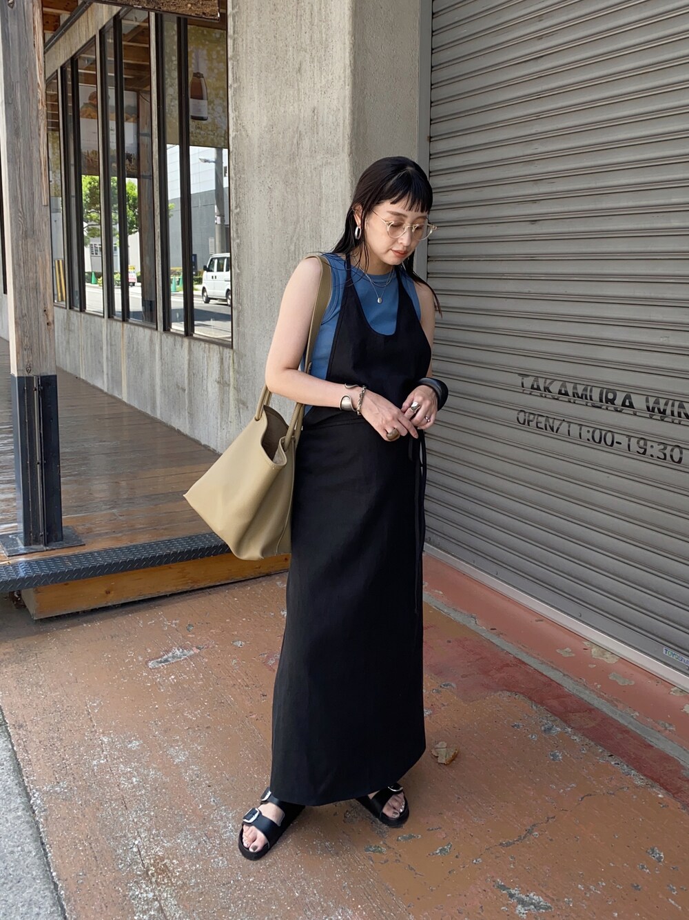 ブラック系のワンピース、ベージュ系のハンドバッグ、ブルー系のタンクトップを着用したレディースの夏コーディネートの1枚目の写真