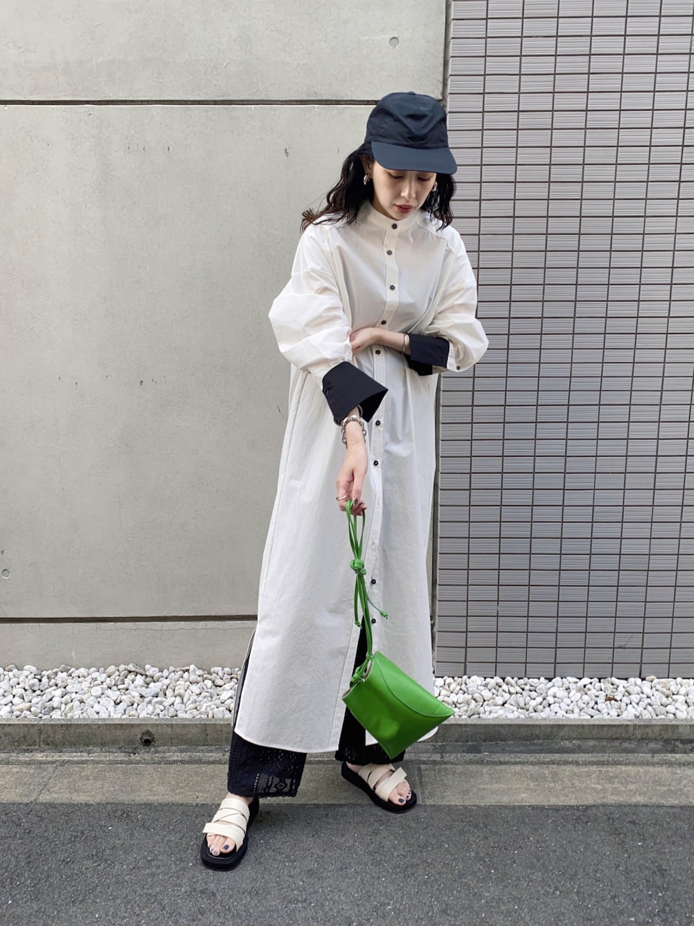 グリーン系のハンドバッグ、ブラック系のその他パンツ、ブラック系のシャツワンピースを着用したレディースの春コーディネートの1枚目の写真