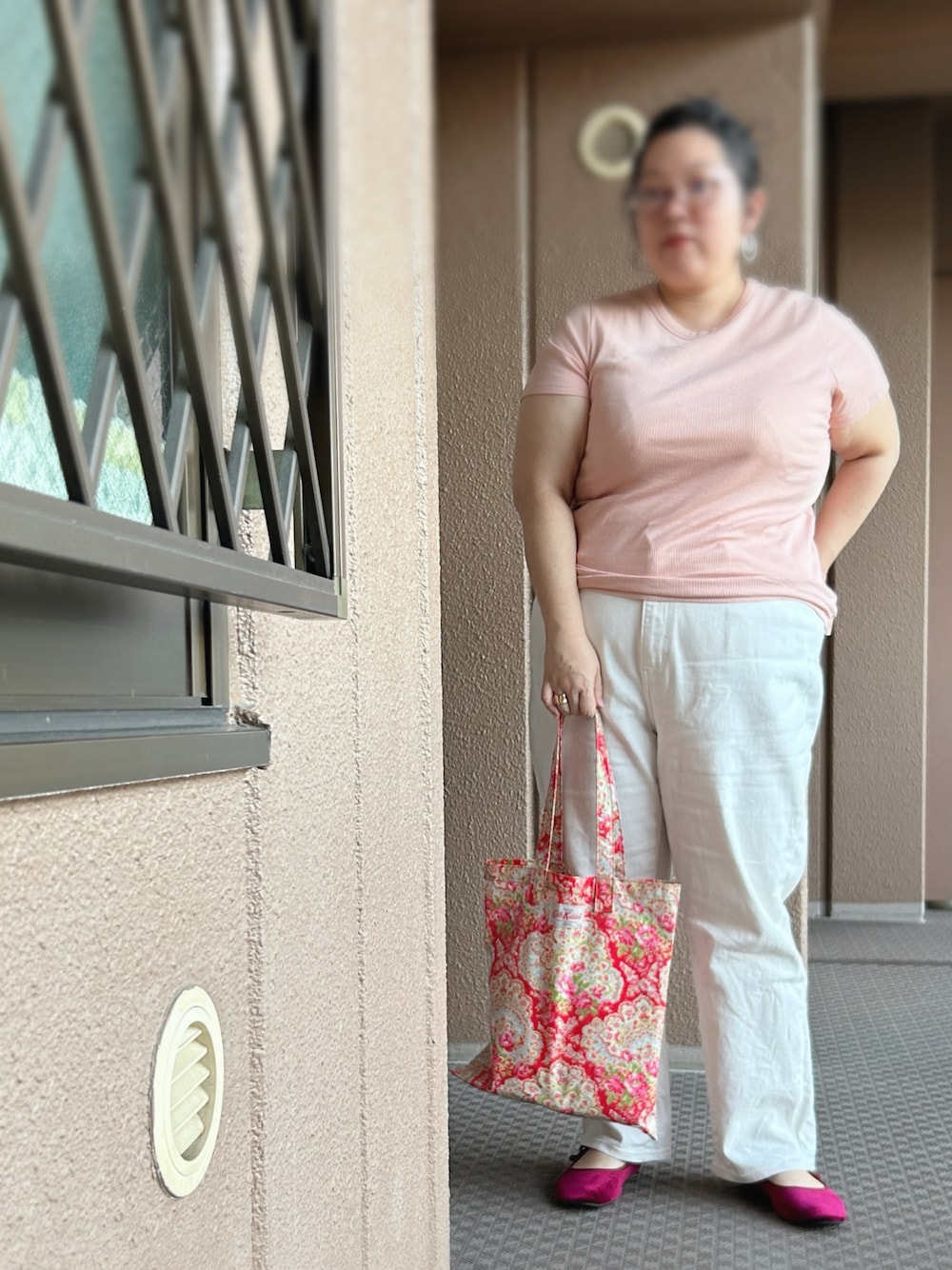 レッド系のトートバッグ、レッド系のバレエシューズ、ピンク系のTシャツ/カットソーを着用したレディースの秋コーディネートの1枚目の写真