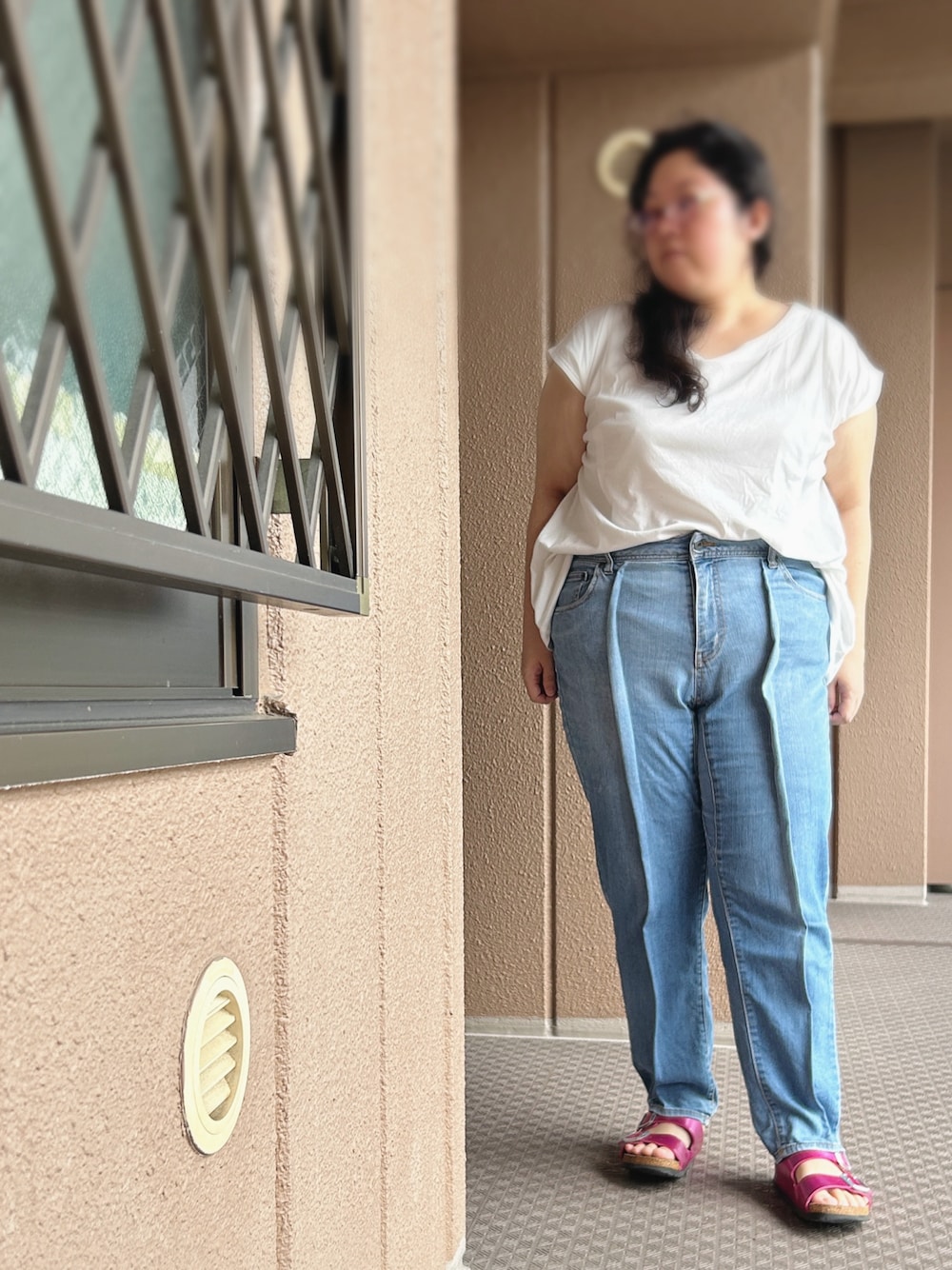 ブルー系のデニムパンツ、ホワイト系のTシャツ/カットソー、ピンク系のサンダルを着用したレディースの秋コーディネートの1枚目の写真