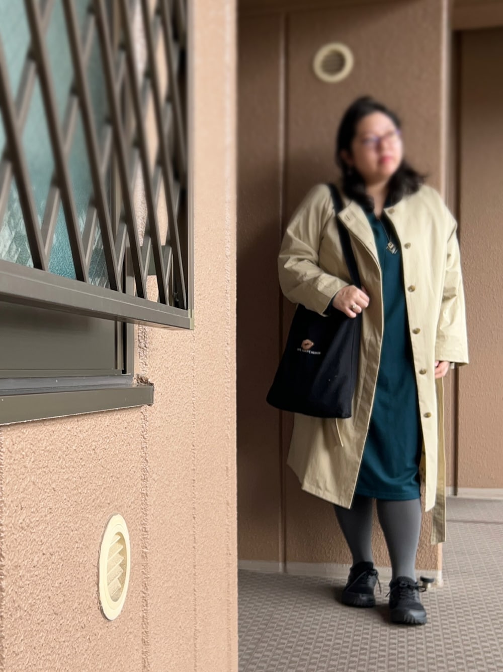 グリーン系のワンピース、ベージュ系のジャケット/アウター、ブラック系のトートバッグを着用したレディースの秋コーディネートの1枚目の写真