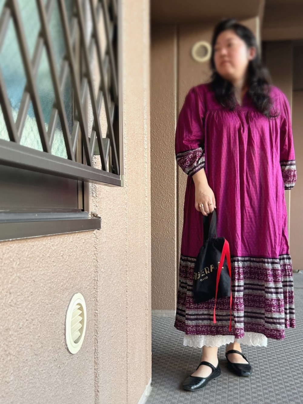 ピンク系のワンピース、ブラック系のトートバッグ、ホワイト系のその他パンツを着用したレディースの秋コーディネートの1枚目の写真