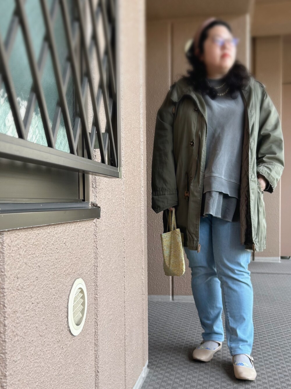 グレー系のスウェット、グリーン系のモッズコート、グリーン系のトートバッグを着用したレディースの春コーディネートの1枚目の写真