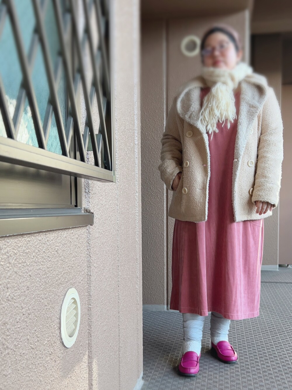 ピンク系のワンピース、ベージュ系のピーコート、ピンク系のその他シューズを着用したレディースの冬コーディネートの1枚目の写真