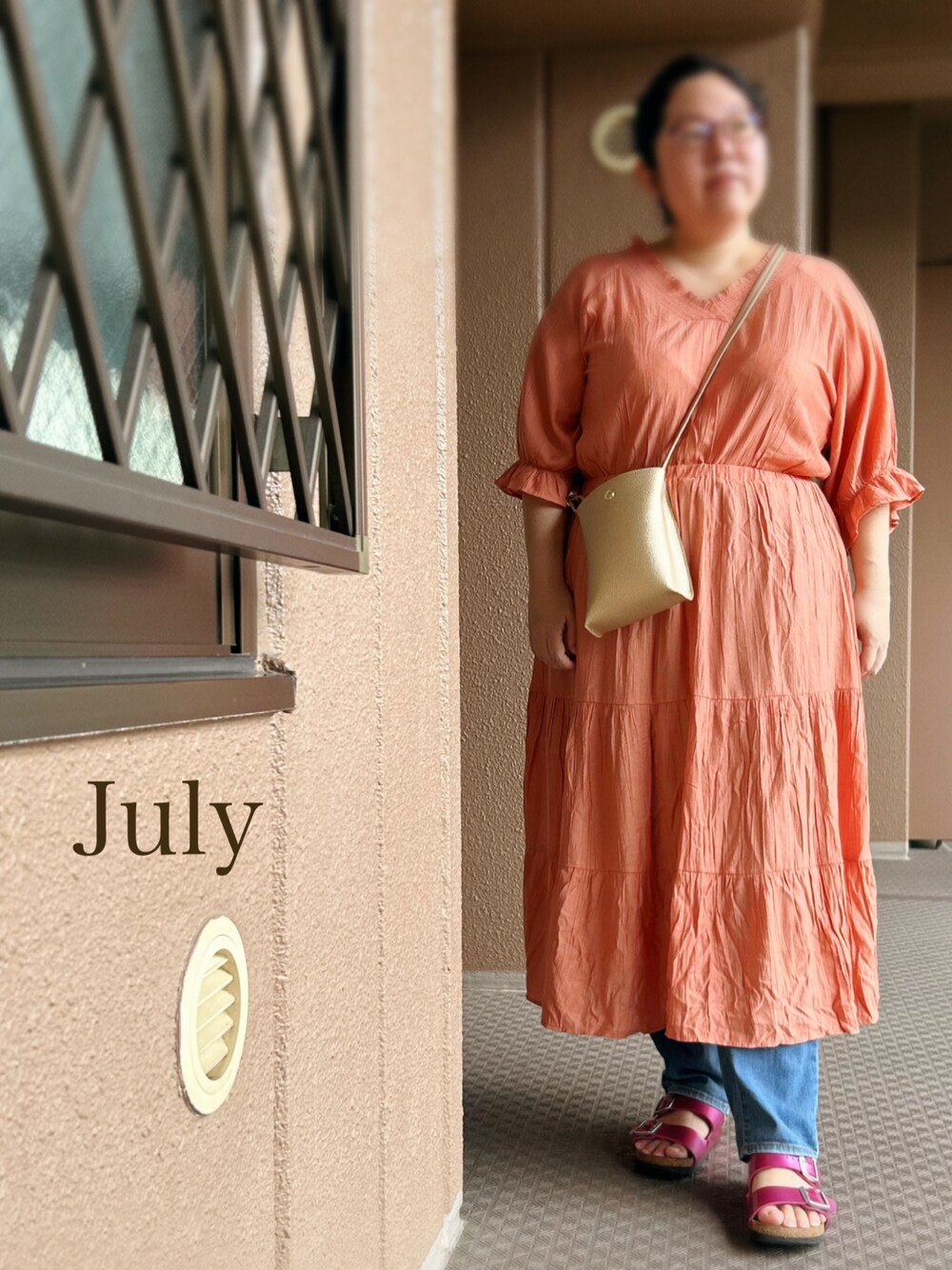 オレンジ系のワンピース、ゴールド系のショルダーバッグ、その他のパンツを着用したレディースの夏コーディネートの1枚目の写真