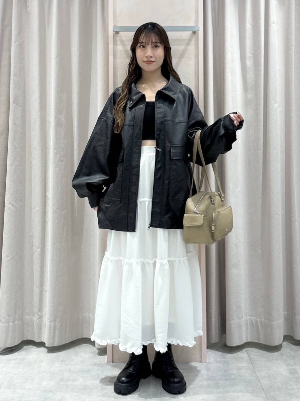 ブラック系のキャミソール、ブラック系のブルゾン、ベージュ系のボストンバッグを着用したレディースの秋コーディネートの1枚目の写真