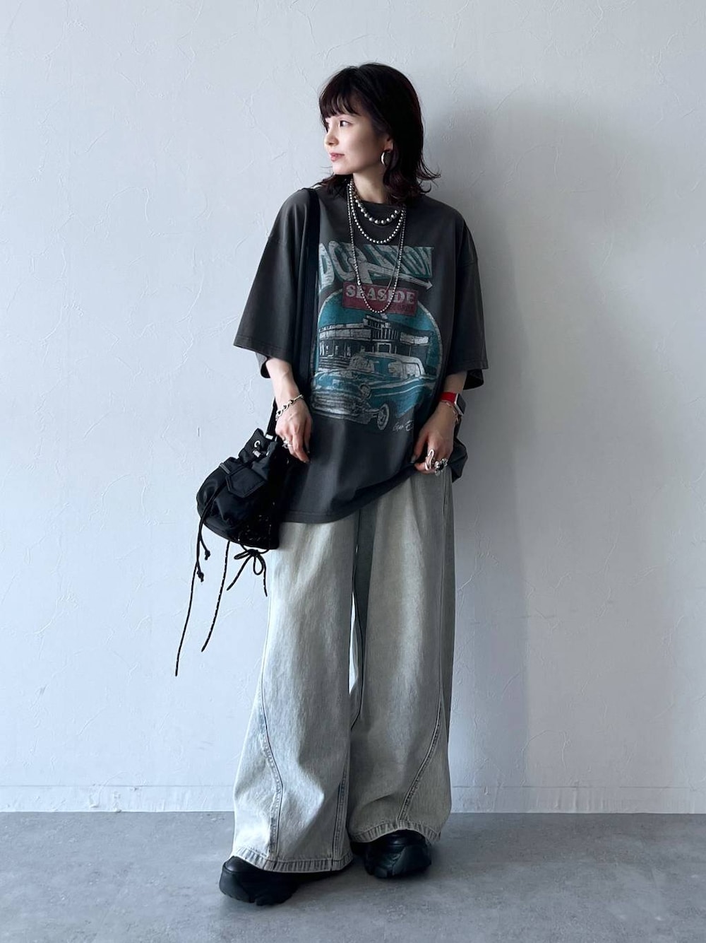 ブラック系のスニーカー、ブルー系のデニムパンツ、グレー系のTシャツ/カットソーを着用したレディースの夏コーディネートの1枚目の写真