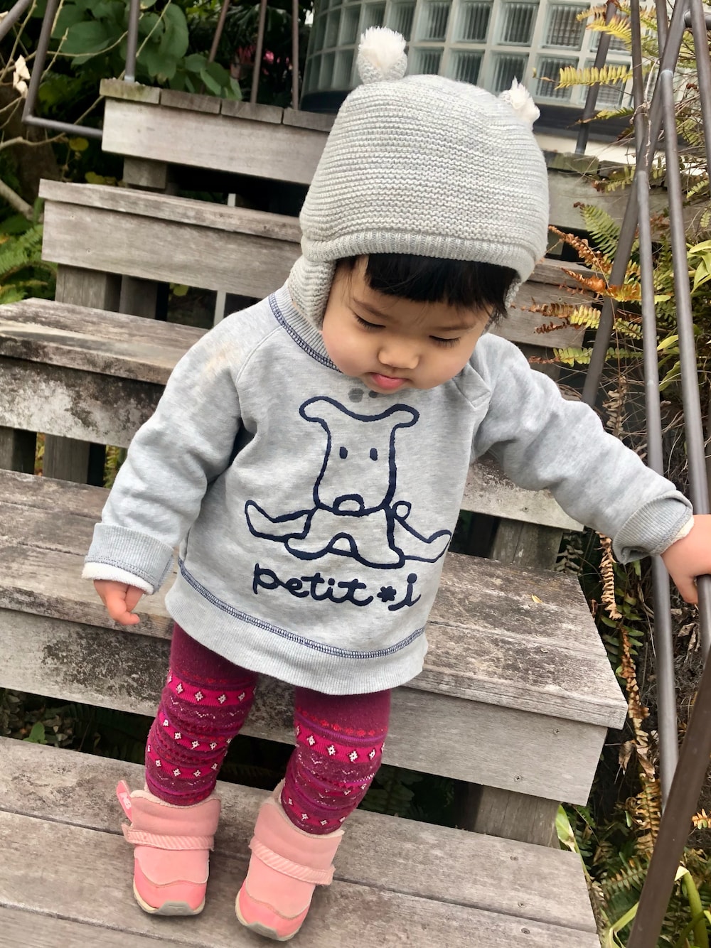 グレー系のスウェット、ピンク系のスニーカー、グレー系のニットキャップ/ビーニーを着用したキッズの冬コーディネートの1枚目の写真