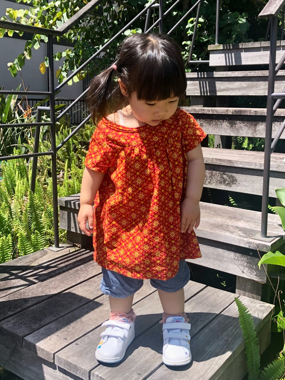 「ハンドメイド、ハンドメイド子供服、handmade、白スニーカー、リーボック(Reebok)、reebok、apreslescours、デニム、デニムパンツ、ハーフパンツ、ショートパンツ、花柄、花柄ブラウス、花柄トップス、チュニック」｜「Handmadeのリボンスモッグ（シャツ/ブラウス、レッド系）」を使った、hanamaruさん（キッズ・80cm）の春コーディネートの1枚目の写真
