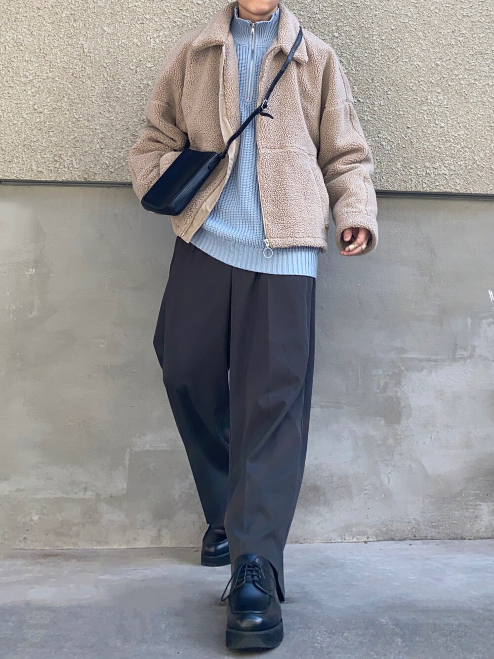 ブルー系のニット/セーター、グレー系のスラックス、ブラック系のドレスシューズを着用したメンズの冬コーディネートの1枚目の写真