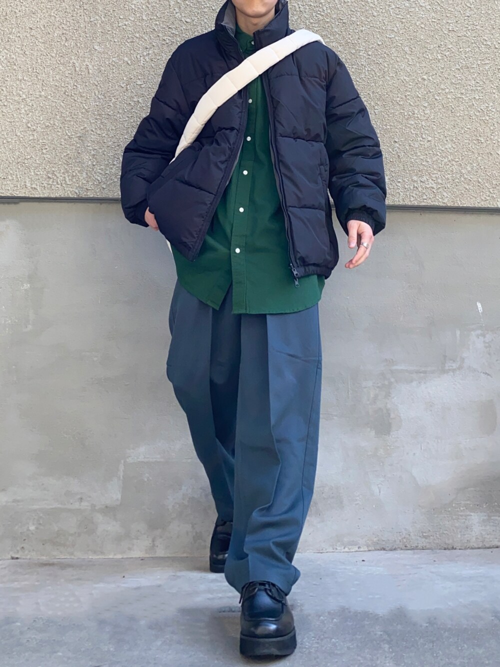 ブラック系のダウンジャケット/コート、グレー系のスラックス、ホワイト系のショルダーバッグを着用したメンズの秋コーディネートの1枚目の写真