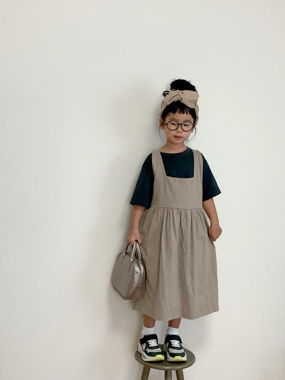 ブラック系のTシャツ/カットソー、ホワイト系のスニーカー、その他のハンドバッグを着用したキッズの秋コーディネートの1枚目の写真