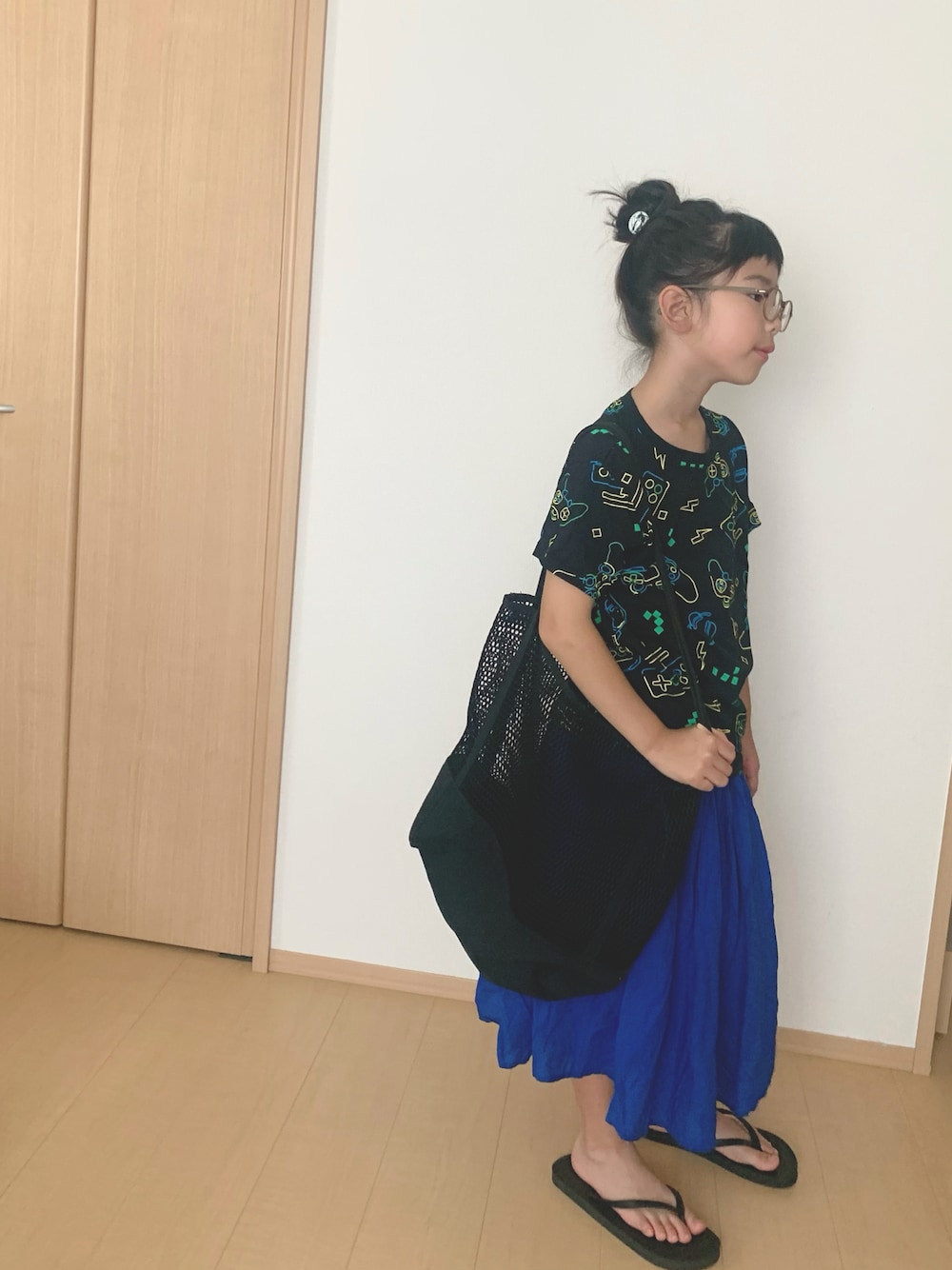 ブラック系のサンダル、ブラック系のトートバッグ、ブラック系のTシャツ/カットソーを着用したキッズの夏コーディネートの1枚目の写真