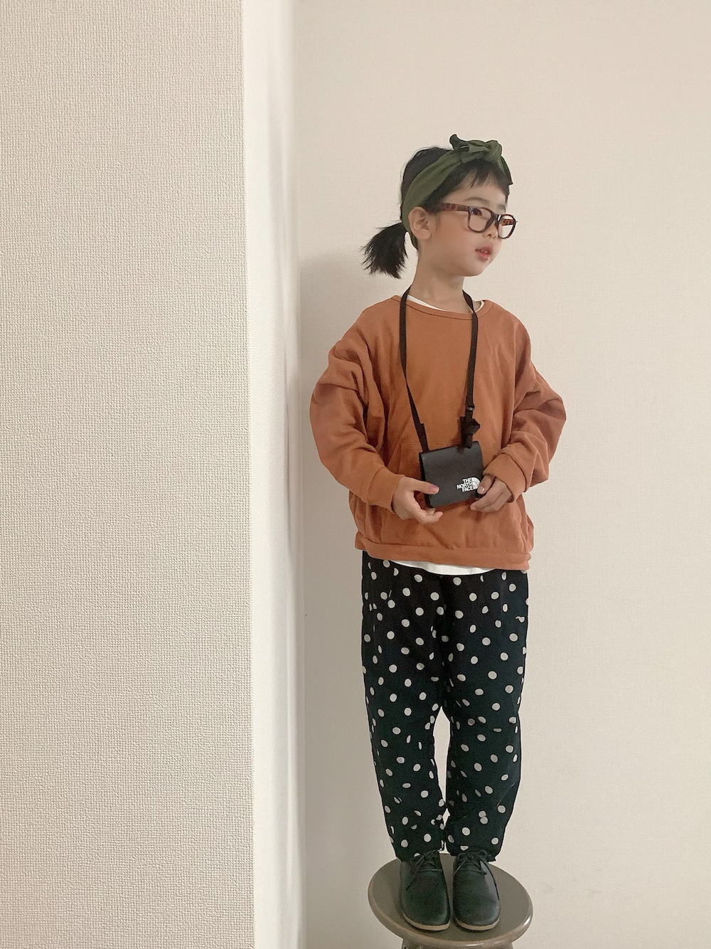 ブラック系のその他パンツ、ブラック系のシューズ、ブラック系のショルダーバッグを着用したキッズの秋コーディネートの1枚目の写真