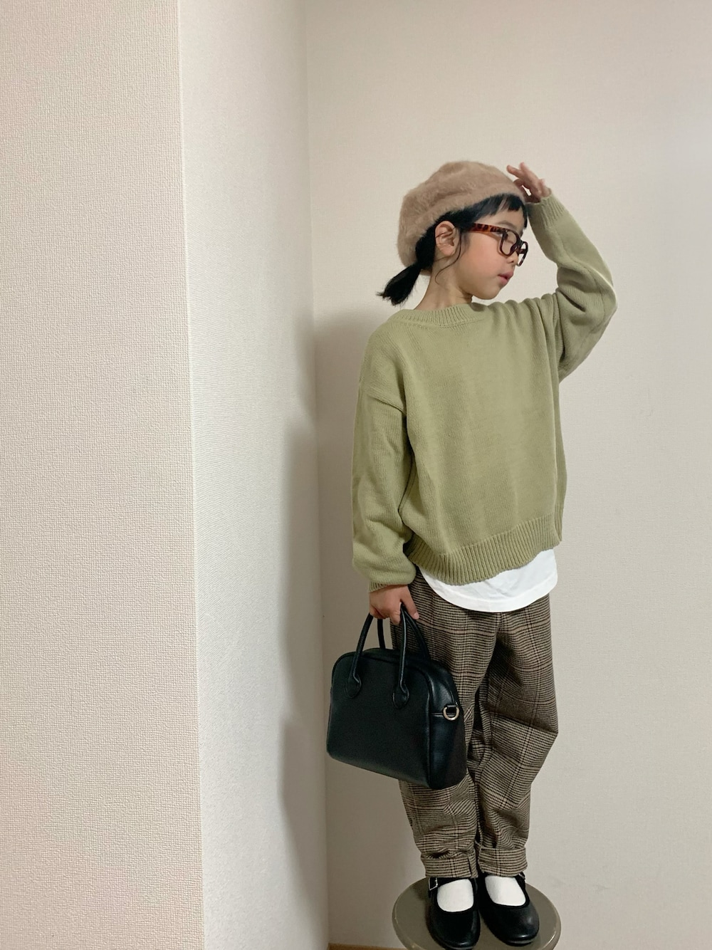 ブラウン系のパンツ、ブラック系のバッグ、ブラック系のバレエシューズを着用したキッズの冬コーディネートの1枚目の写真
