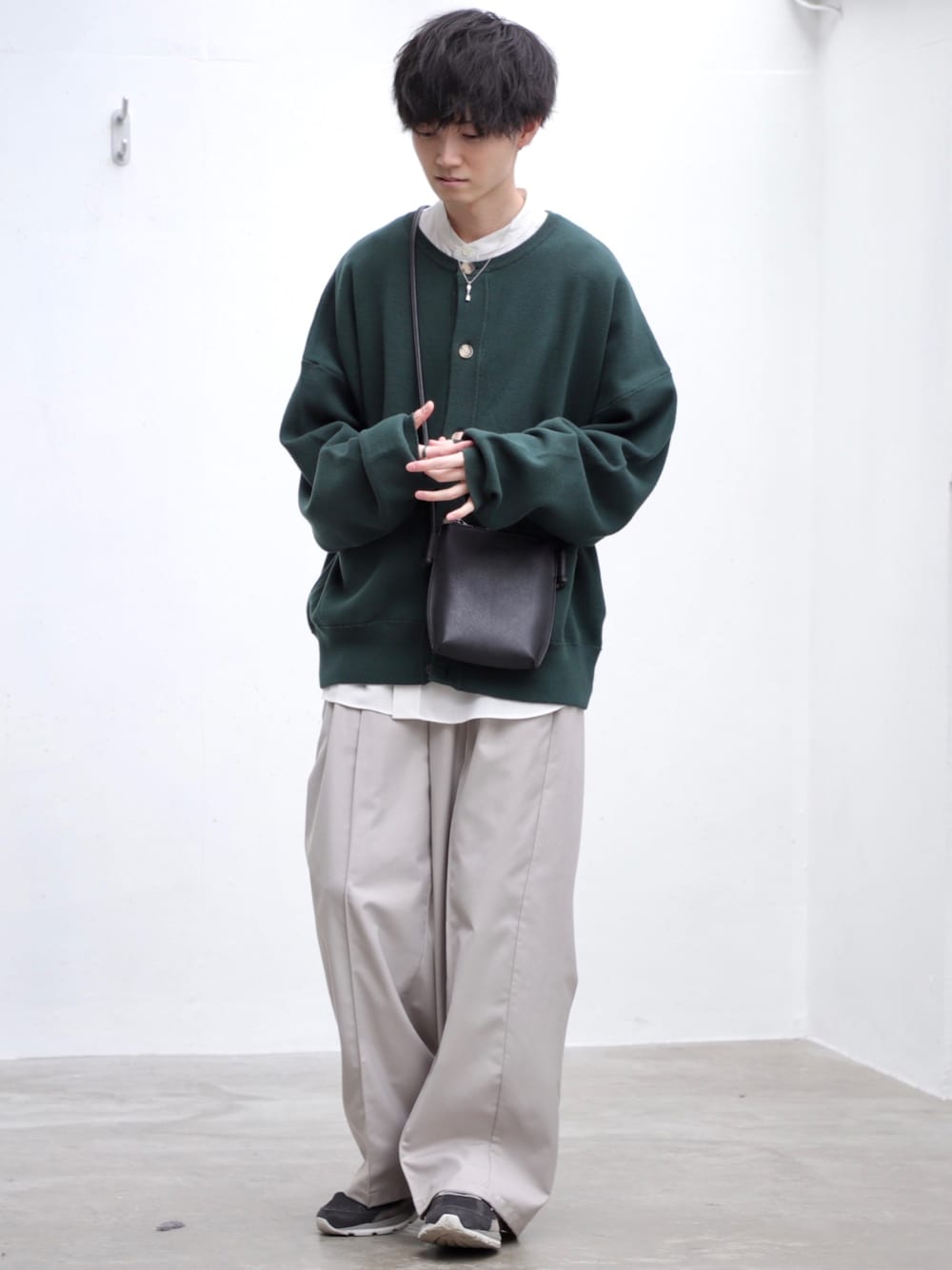 グリーン系のカーディガン/ボレロ、ホワイト系のシャツ/ブラウス、ブラック系のショルダーバッグを着用したメンズの春コーディネートの1枚目の写真