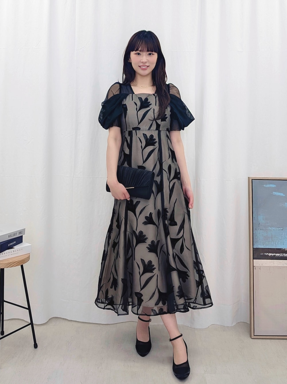 ブラック系のドレスを着用したレディースの春コーディネートの1枚目の写真
