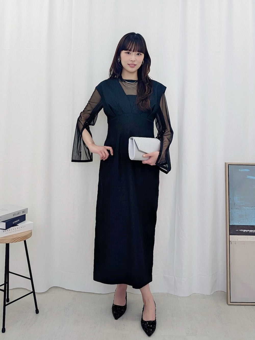 ブラック系のドレスを着用したレディースの春コーディネートの1枚目の写真