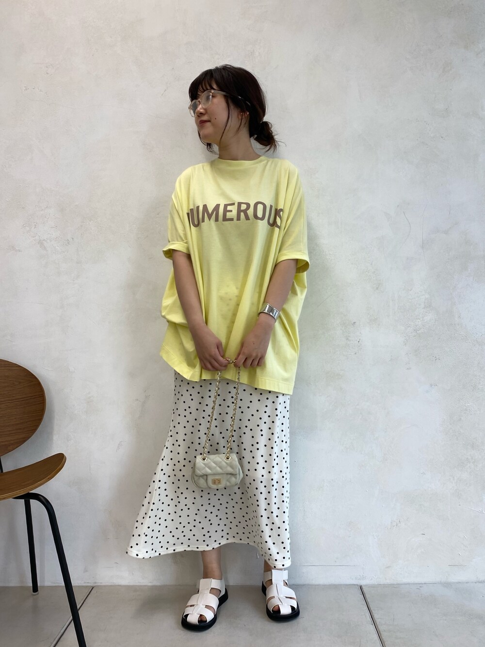 ホワイト系のサンダル、ホワイト系のショルダーバッグ、イエロー系のトップスを着用したレディースの春コーディネートの3枚目の写真