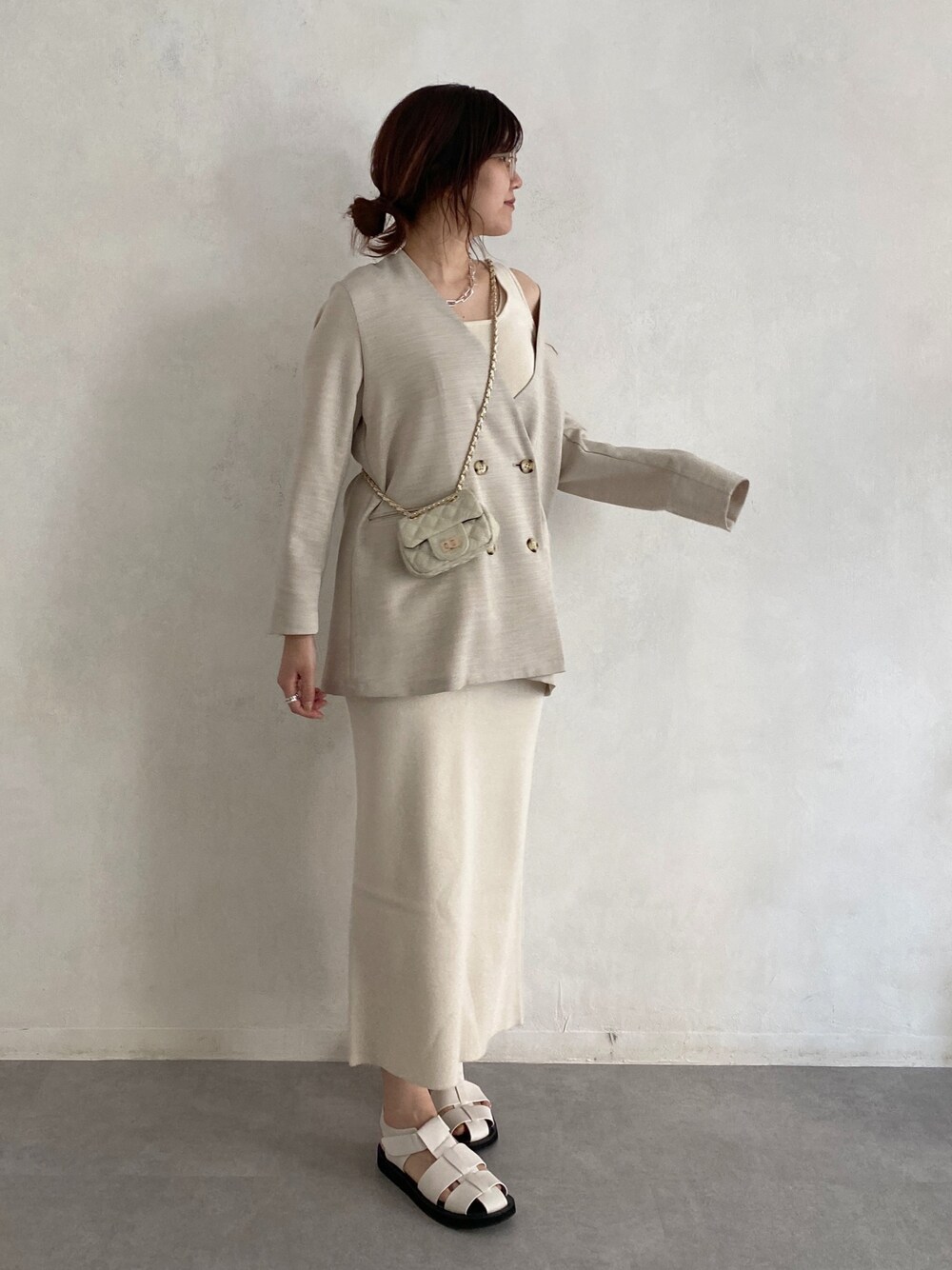 ベージュ系のノーカラージャケット、ベージュ系のトップス、ホワイト系のショルダーバッグを着用したレディースの春コーディネートの2枚目の写真