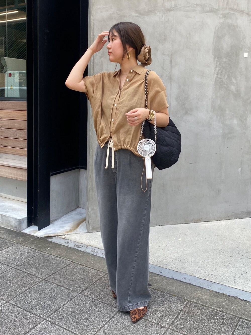 ベージュ系のシャツ/ブラウス、ブラック系のデニムパンツ、ブラウン系のシュシュを着用したレディースの夏コーディネートの1枚目の写真