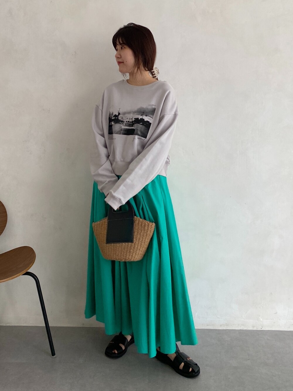 ベージュ系のTシャツ/カットソー、ブルー系のスカート、ブラック系のサンダルを着用したレディースの春コーディネートの5枚目の写真