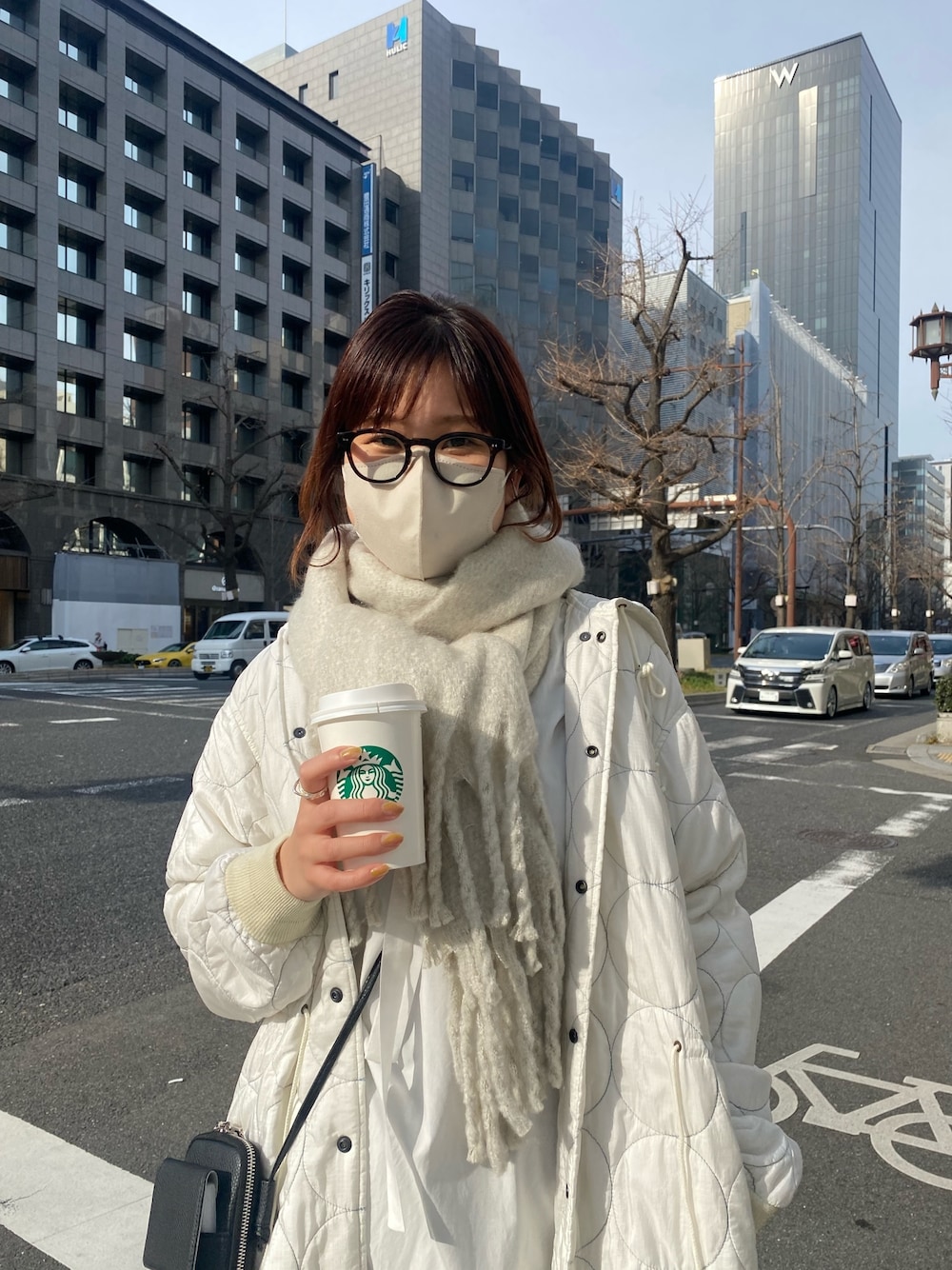 ホワイト系のジャケット/アウター、ブラック系のブーツ、ブラック系のショルダーバッグを着用したレディースの冬コーディネートの3枚目の写真