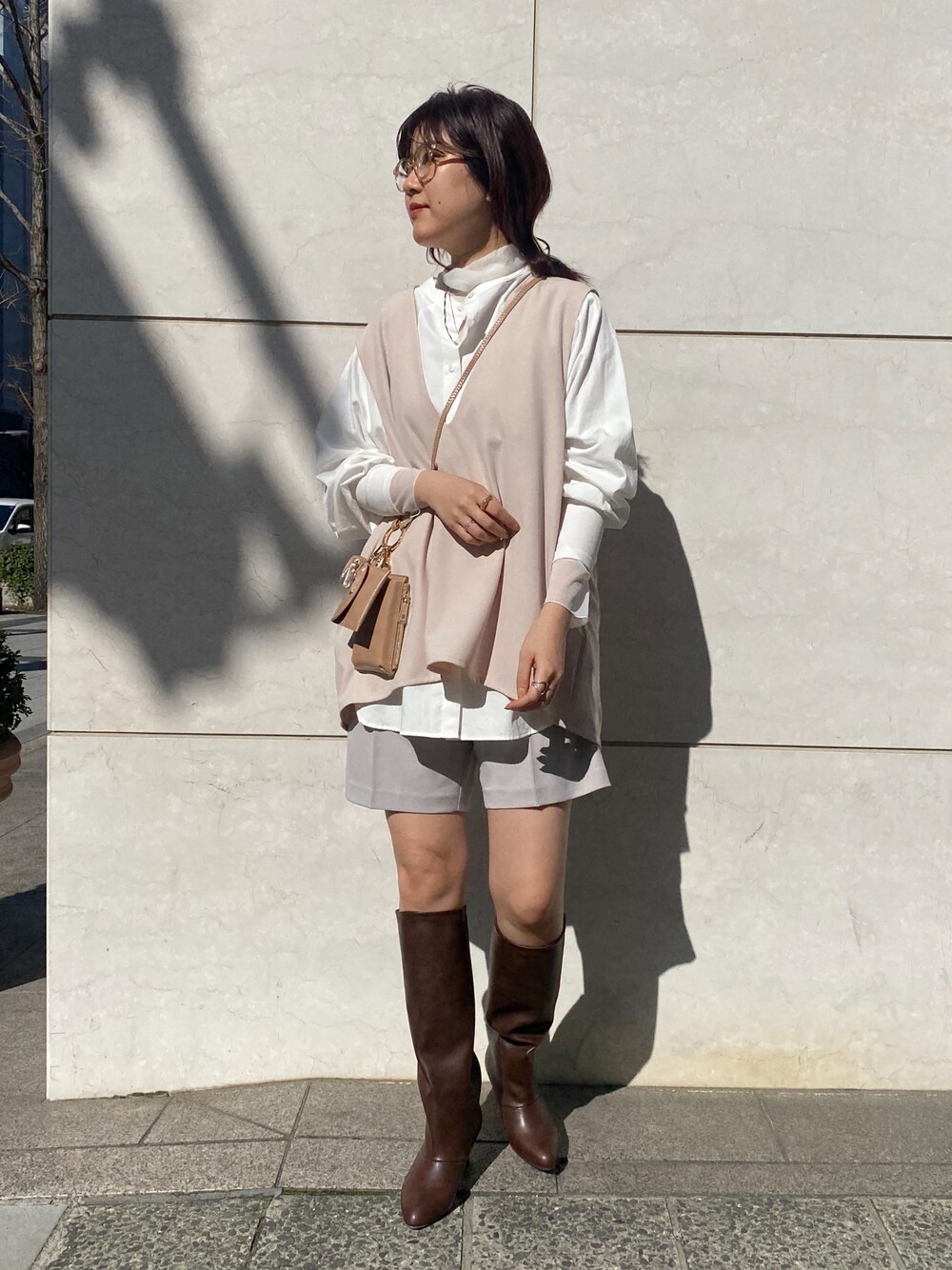 ベージュ系のベスト、ホワイト系のシャツ/ブラウス、ホワイト系のTシャツ/カットソーを着用したレディースの冬コーディネートの2枚目の写真