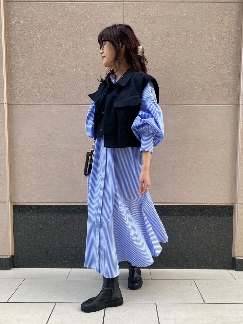 その他のベスト、ブルー系のワンピース、ブラック系のショルダーバッグを着用したレディースの冬コーディネートの4枚目の写真