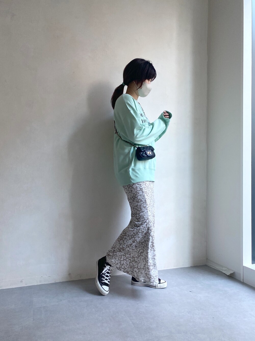 グリーン系のTシャツ/カットソー、ベージュ系のスカート、ブラウン系のスニーカーを着用したレディースの冬コーディネートの4枚目の写真