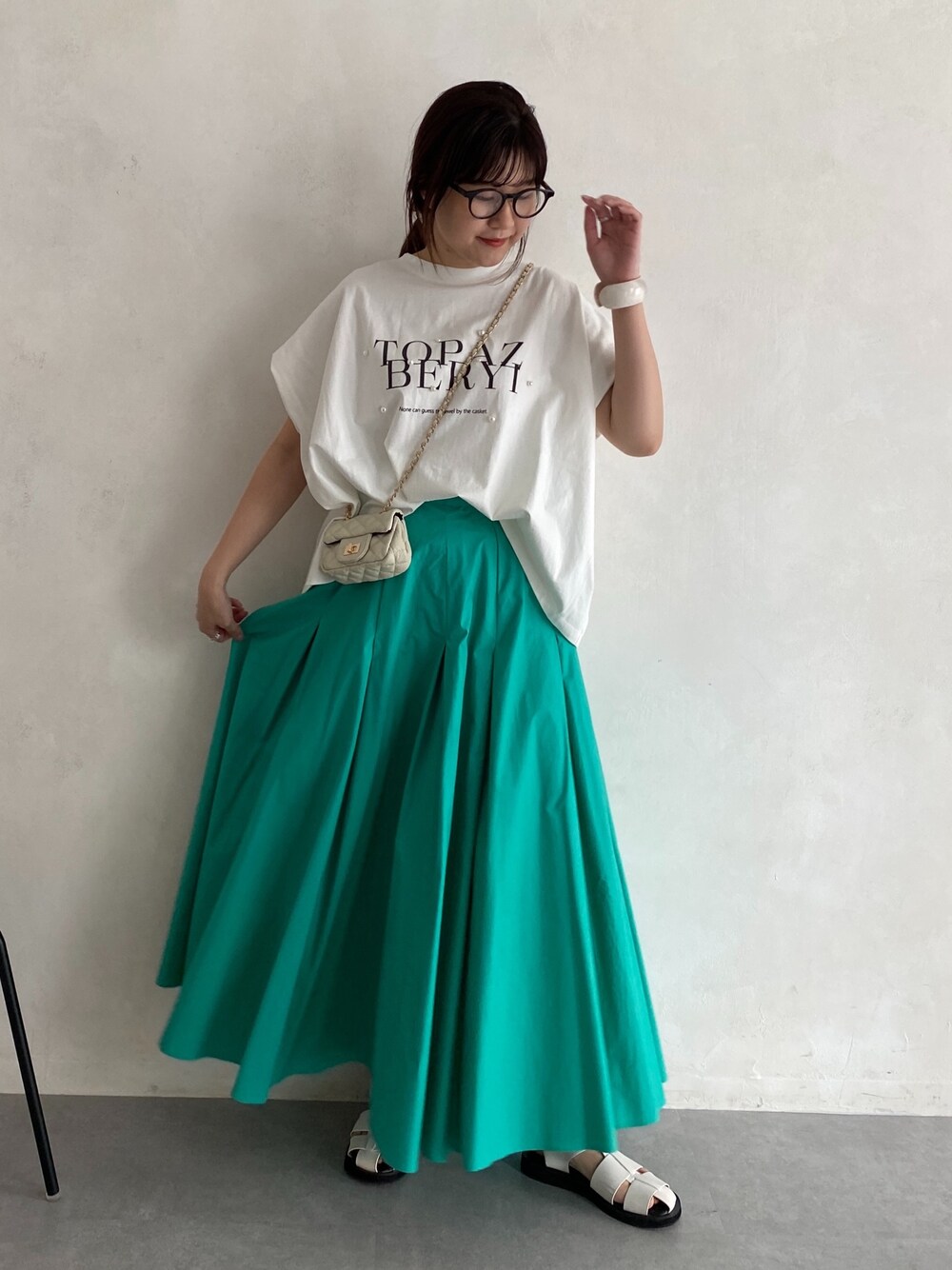 ホワイト系のTシャツ/カットソー、ブルー系のスカート、ホワイト系のショルダーバッグを着用したレディースの春コーディネートの2枚目の写真