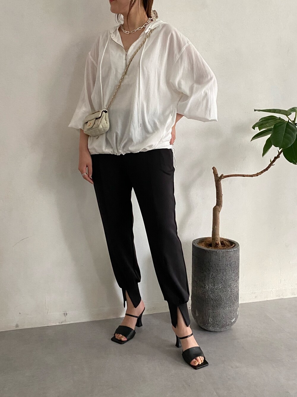 ホワイト系のシャツ/ブラウス、ホワイト系のショルダーバッグ、ブラック系のその他パンツを着用したレディースの春コーディネートの5枚目の写真
