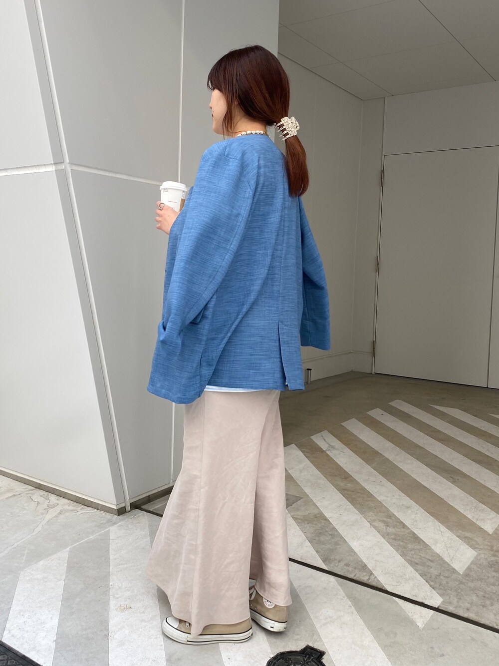 ブルー系のノーカラージャケット、ブルー系のTシャツ/カットソー、ベージュ系のスカートを着用したレディースの春コーディネートの2枚目の写真