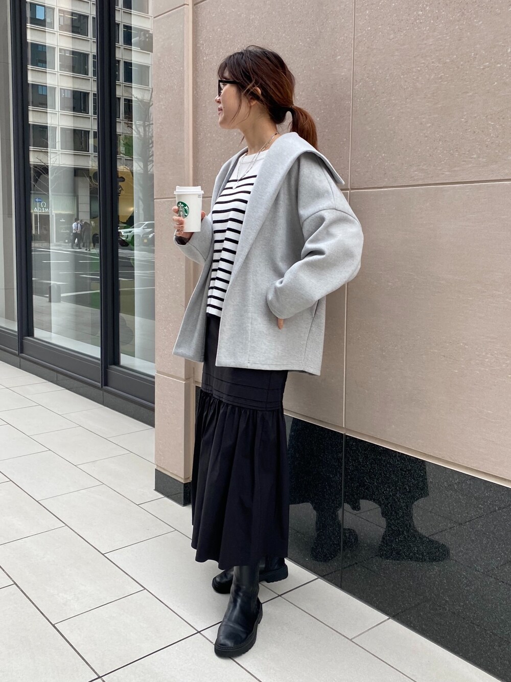 グレー系のその他アウター、ブラック系のニット/セーター、ブラック系のスカートを着用したレディースの冬コーディネートの2枚目の写真