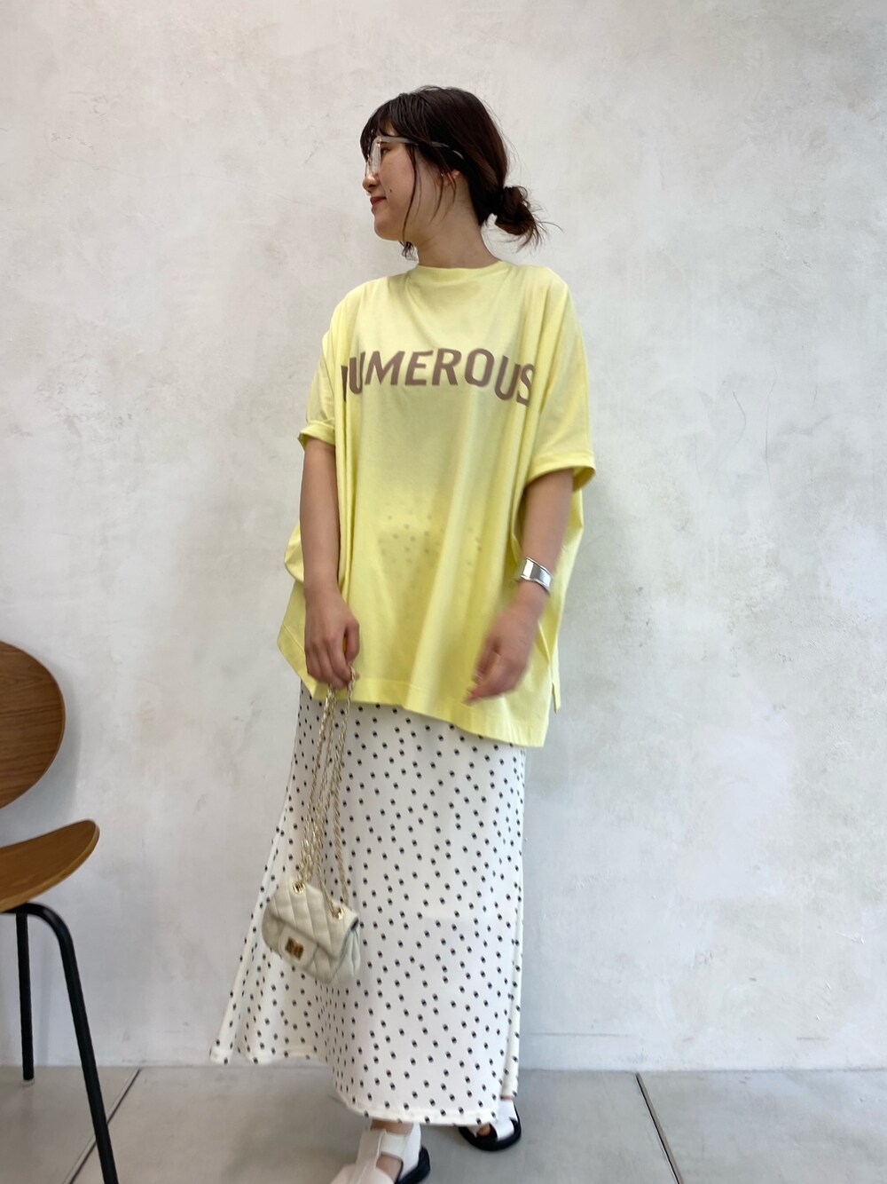 ホワイト系のサンダル、ホワイト系のショルダーバッグ、イエロー系のトップスを着用したレディースの春コーディネートの2枚目の写真