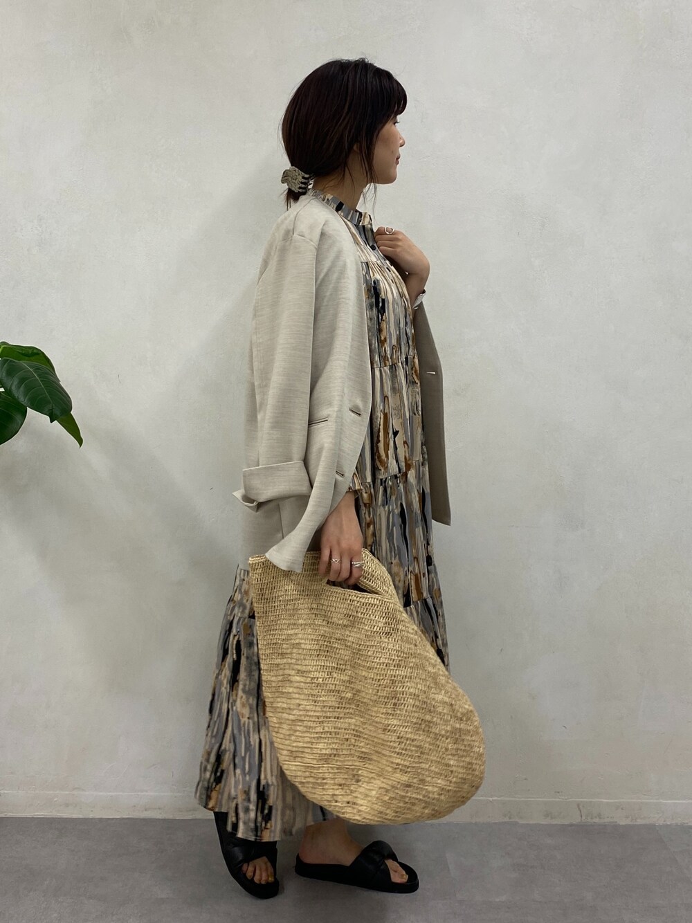 ブラウン系のワンピース、ベージュ系のノーカラージャケット、シルバー系のブレスレットを着用したレディースの春コーディネートの2枚目の写真